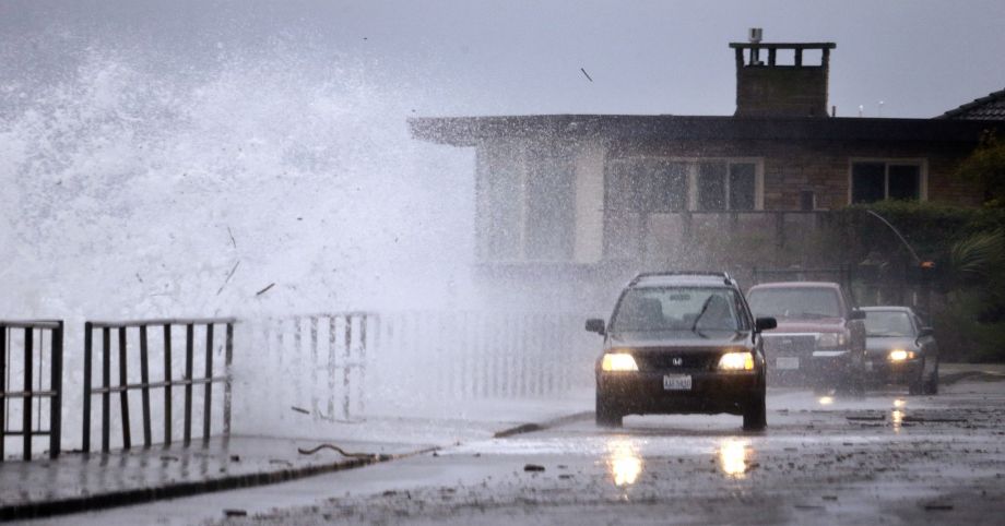 Debris from the beach below is tossed up and over a seawall by wind-blown waves and toward traffic Tuesday Nov. 17 2015 in the West Seattle neighborhood of Seattle. Rain and high winds snarled the morning commute in the Puget Sound area and the Inland