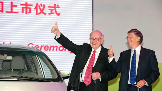 Business investors Warren Buffett and Bill Gates gesture at the nationwide launching ceremony of Chinese electric vehicle BYD M6 in Beijing