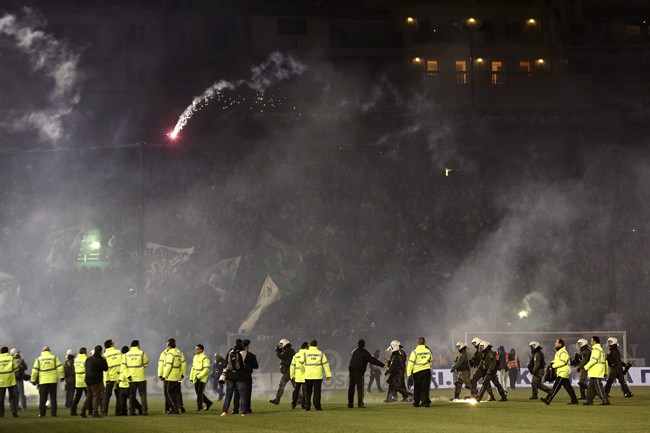 CORRECTS YEAR- Panathinaikos fans throw flares as policemen and security personnel enter the pitch of Apostolos Nikolaides stadium after the cancellation of the Greek Super League match between Panathinaikos and Olympiakos in Athens Saturday Nov. 21