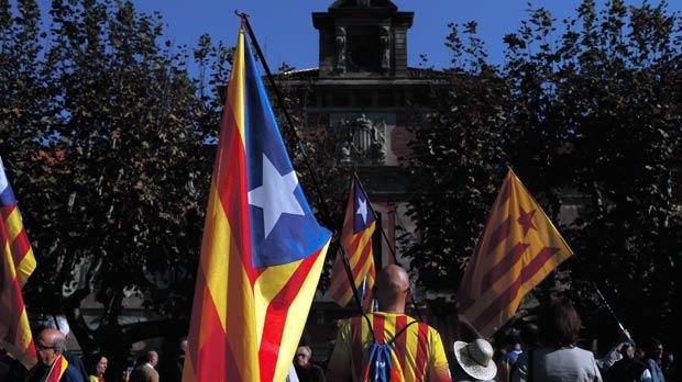 People hold estelada or pro-independence flags at parliament in Barcelona Spain yesterday