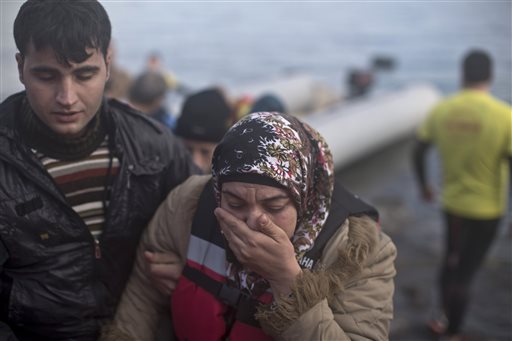 A woman is helped after arriving on a small boat on the northern shore of Lesbos Greece Tuesday Nov. 10 2015. Over half a million people have reached the Greek islands so far this year a record number of arrivals and the journey has proved fatal for