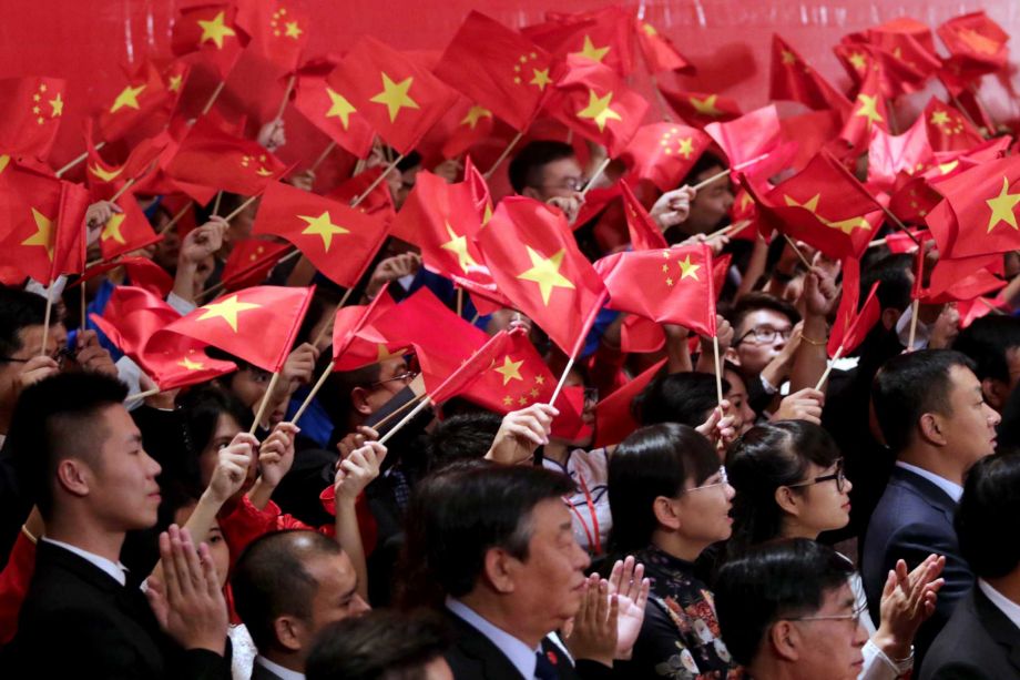 Vietnamese and Chinese communist youths wave flags to welcome Chinese President Xi Jinping and Vietnamese Communist Party General Secretary Nguyen Phu Trong at a meeting in Hanoi Vietnam Friday Nov. 6 2015