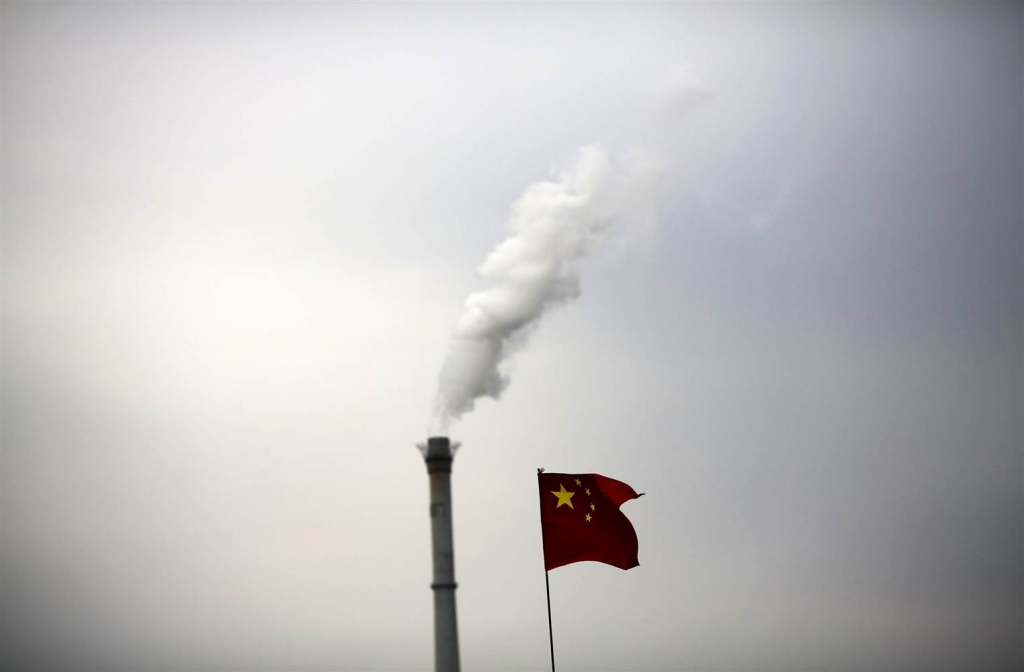 China's national flag is seen in front of a chimney of a cogeneration plant in Beijing China. KIM KYUNG-HOON  Reuters file