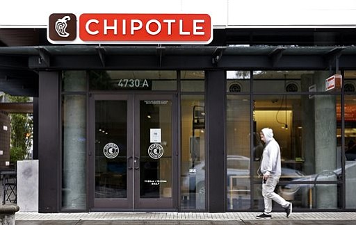 A pedestrian walks past a closed Chipotle restaurant Monday Nov. 2 2015 in Seattle. An E. coli outbreak linked to Chipotle restaurants in Washington state and Oregon has sickened nearly two dozen people in the third outbreak of foodborne illness at the