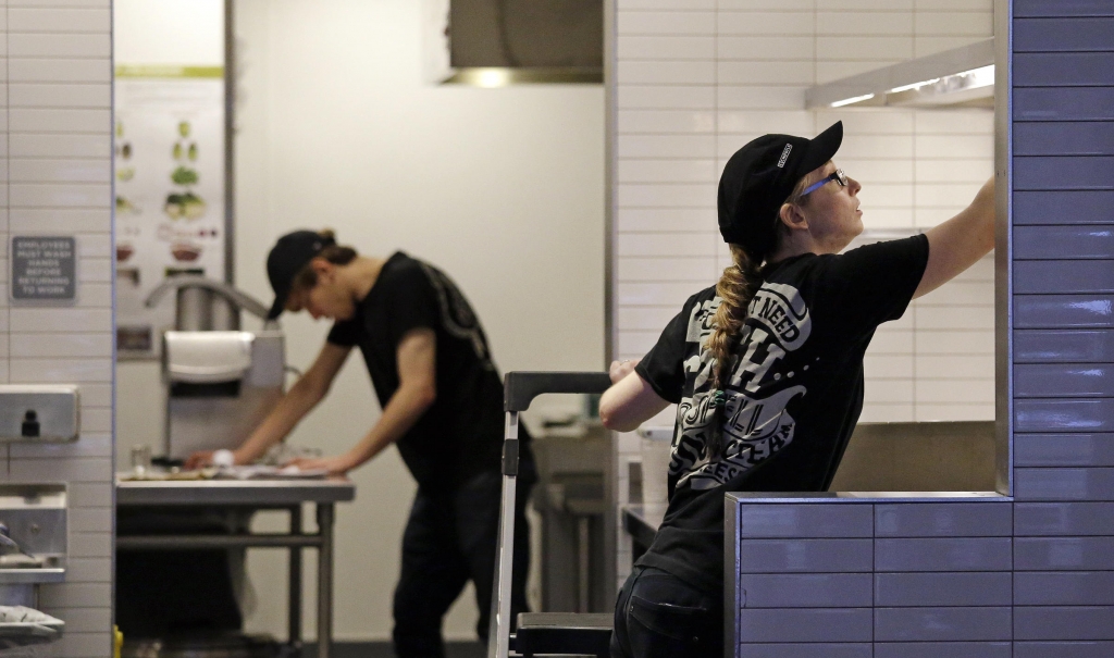 Workers clean inside a still-closed Chipotle restaurant Monday Nov. 9 2015 in Seattle. Health officials in Washington and Oregon have said that more than three dozen people have gotten sick with E. coli in an outbreak linked to Chipotle restaurants