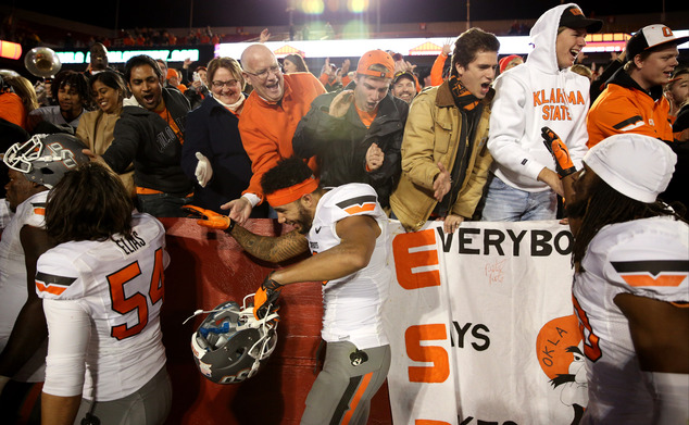 Oklahoma State fans celebrate with the Oklahoma State wide receiver Marcell Ateman after their 35-31 victory over Iowa State during an NCAA college football