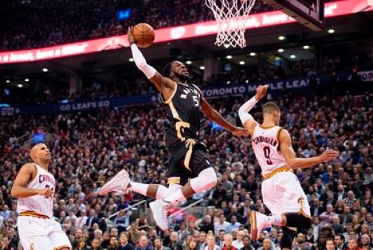 Toronto Raptors De Marre Carroll centre goes for the dunk between Cleveland Cavaliers Richard Jefferson left and Jared Cunningham during first half NBA basketball action in Toronto on Wednesday