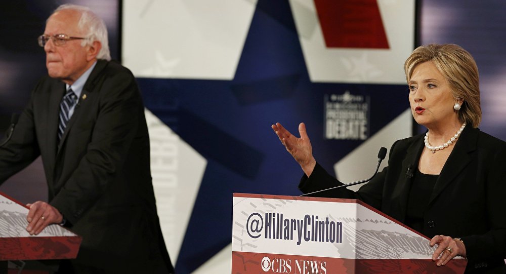 Democratic U.S. presidential candidate former Secretary of State Hillary Clinton speaks as fellow candidate and Senator Bernie Sanders listens during the second official 2016 U.S. Democratic presidential candidates debate