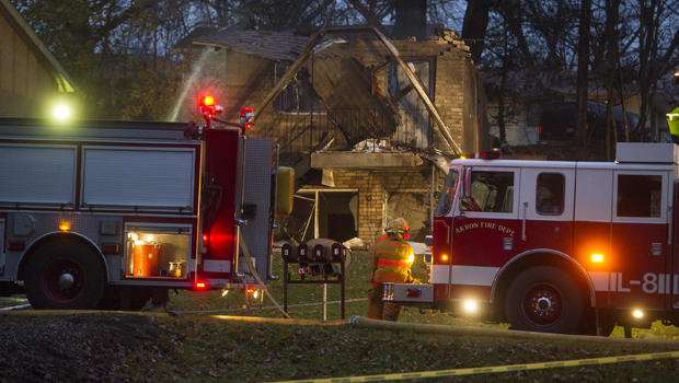 Firefighters work at the scene where authorities say a small business jet crashed into an apartment building in Akron Ohio Nov. 10 2015