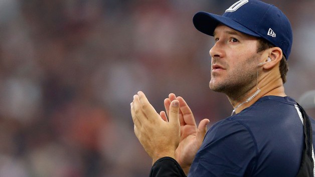 ARLINGTON TX- OCTOBER 11 Quarterback Tony Romo #9 of the Dallas Cowboys watches from the sideline against the New England Patriots during the first half of the NFL game at AT&T Stadium