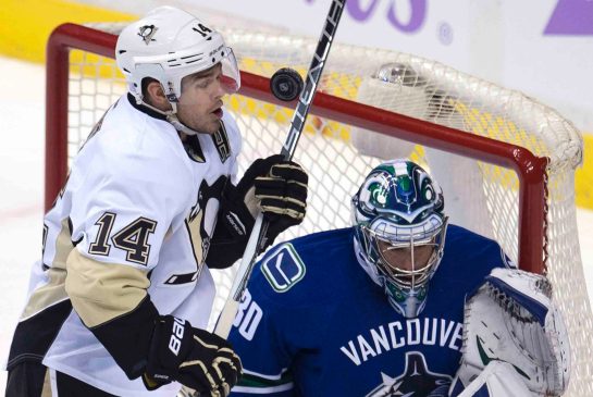 Pittsburgh Penguins forward Chris Kunitz left tries to get a shot past Vancouver Canucks goalie Ryan Miller during the first period of Wednesday's NHL game in in Vancouver B.C