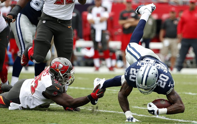 Dallas Cowboys running back Darren Mc Fadden gets tripped up by Tampa Bay Buccaneers defensive end Howard Jones during the second quarter of an NFL football game Sunday Nov. 15 2015 in Tampa Fla