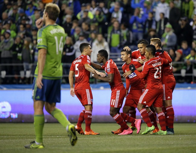 Seattle Sounders Chad Marshall left walks to the center of the field as FC Dallas players celebrate after Dallas Fabian Castillo third from left scored a goal in the first half of an MLS soccer western conference semifinal playoff match Sunday Nov