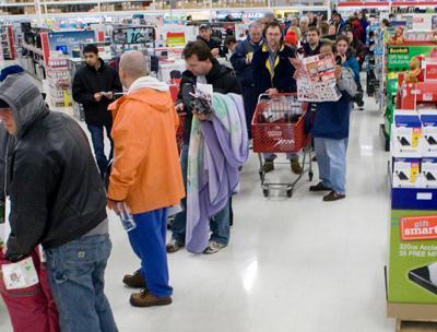 Dozens of people stand in a checkout lane with carts filled with merchandise in Target on Thanksgiving Eve last year. File