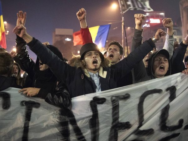 Soccer fans shout slogans against politicians during the sixth night of protests calling for better governance and an end to corruption in Bucharest Romania Sunday night Nov. 8 2015. People power has ousted the Romanian government which resigned aft