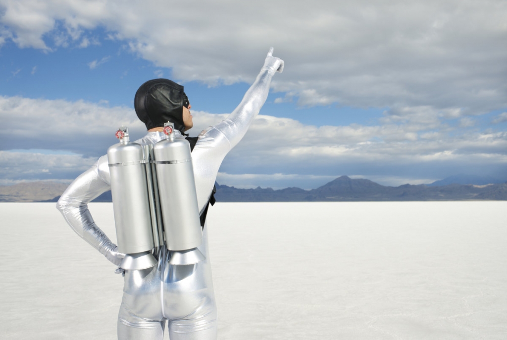 Man Wearing Jet Pack Pointing to Sky