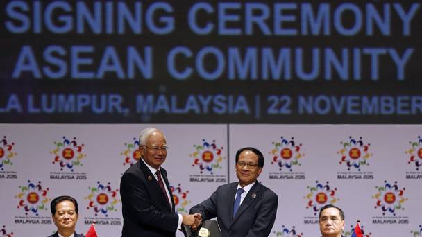 Malaysian prime minister Najib Razak left passes a signed document to Asean secretary general Le Luong Minh of Vietnam after the establishment of the economic community