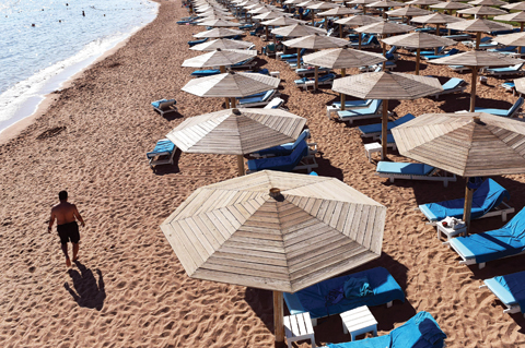 SHARM EL-SHEIKH A tourist walks past sunbeds on a beach in Egypt’s Red Sea resort of Sharm El Sheikh yesterday. As visitors stranded after the crash of a Russian airliner stream home from Egypt Sharm El Sheikh is scrambling to keep its lucrative touri