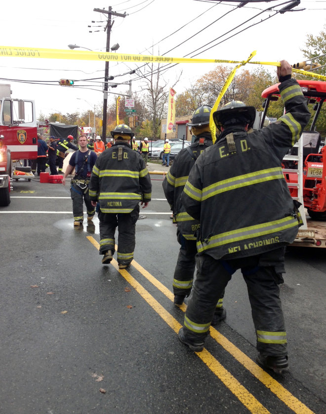 Firefighters respond to the scene of a house explosion on Wednesday Nov. 11 2015 in Elizabeth N.J. The explosion injured at least three people and may have trapped up to five others a city spokeswoman said