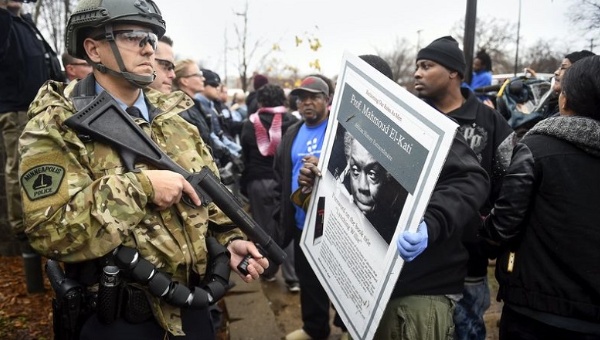 Protesters in Minneapolis hold up a poster of Prof. Mahmoud El Kati a Minnesotan academic and writer on the African American experience in the U.S