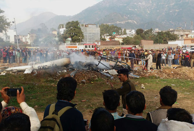 Emergency service personnel and rescue workers gather around the wreckage of the helicopter which crashed at Katra on Monday. Pic  AFP