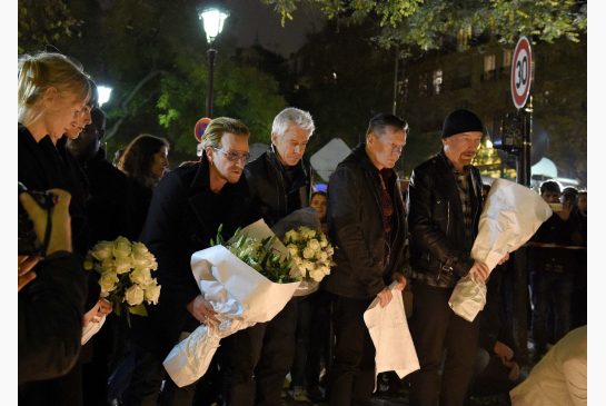 U2 members pay their respects to victims of the Paris attacks near the Bataclan concert hall on Nov. 14. The band has cancelled two sold-out concerts in Paris including one that was to be broadcast live