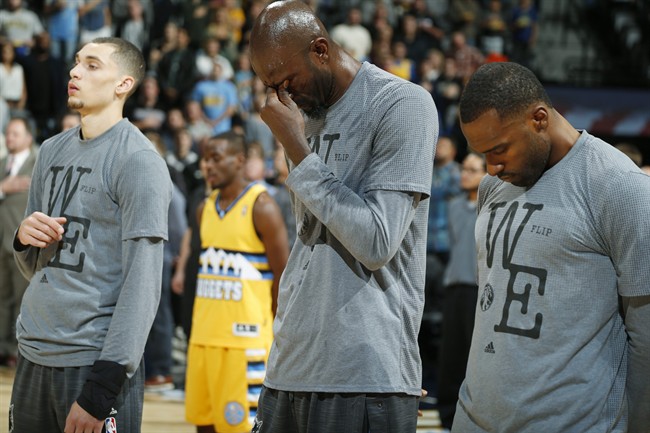 Minnesota Timberwolves forward Kevin Garnett center stands with guard Zach LaVine left and forward Shabazz Muhammad during a tribute to the team's former head coach Flip Saunders before they face the Denver Nuggets in an NBA basketball game Friday Oc