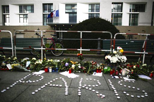 People have placed flowers and candles to mourn for the victims killed in the Friday's attacks in Paris France in front of the French Embassy in Berlin Saturday Nov. 14 2015. French President Francois Hollande said more than 120 people died Friday