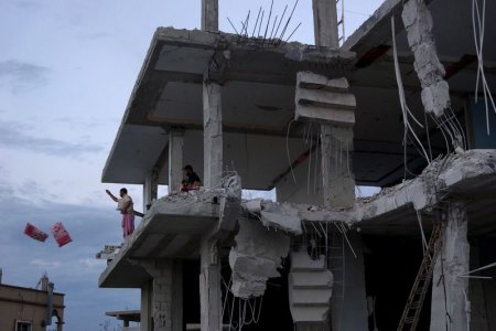 Residents toss belongings from a damaged building from what activists said were airstrikes carried out by the Russian air force in Nawa city Deraa Syria