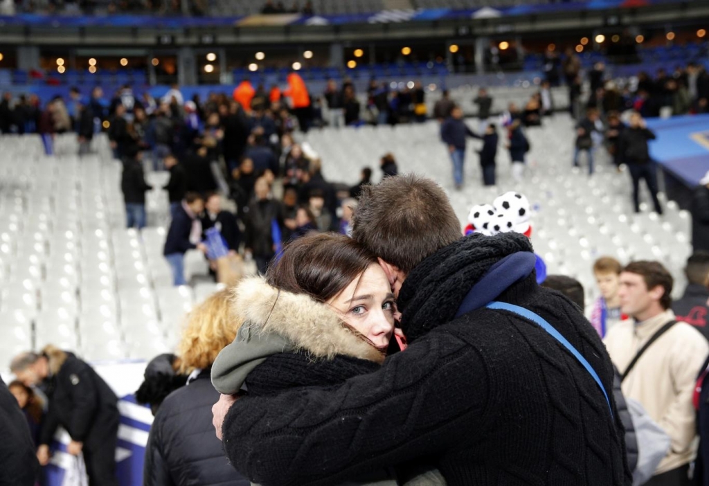 Friends embrace inside the Stade de France stadium in Paris. Christophe Ena AP