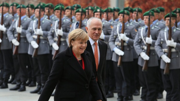 Germany's Chancellor Angela Merkel left and Prime Minister Malcolm Turnbull review an honour guard during a welcoming ceremony prior to a meeting at the German Chancellery in Berlin