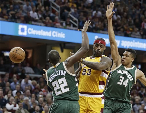 Cleveland Cavaliers Le Bron James passes around Milwaukee Bucks Giannis Antetokounmpo, from Greece and Khris Middleton in the first half of an NBA basketball game Thursday Nov. 19 2015 in Cleveland