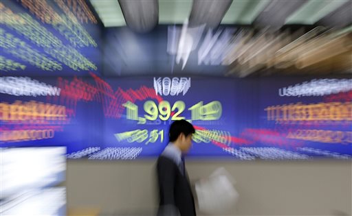 A currency trader walks past the screen showing the Korea Composite Stock Price Index at the foreign exchange dealing room in Seoul South Korea Tuesday Nov. 10 2015. Asian stock markets were mostly lower Tuesday as investors fretted over the