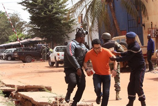 Mali troopers assist a hostage to leave the Radisson Blu hotel to safety after gunmen attacked the hotel in Bamako Mali. The al Qaida-claimed attack on a Mali hotel may have been partly aimed at assertin