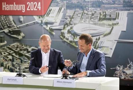 Hamburg Mayor Olaf Scholz left and Alfons Hoermann President of the German Olympic Sports Confederation officially sign Hamburg’s application letter to host the Olympic and Paralympic Games 2024 in Hamburg northern Germany Wednesday Sept. 9 2