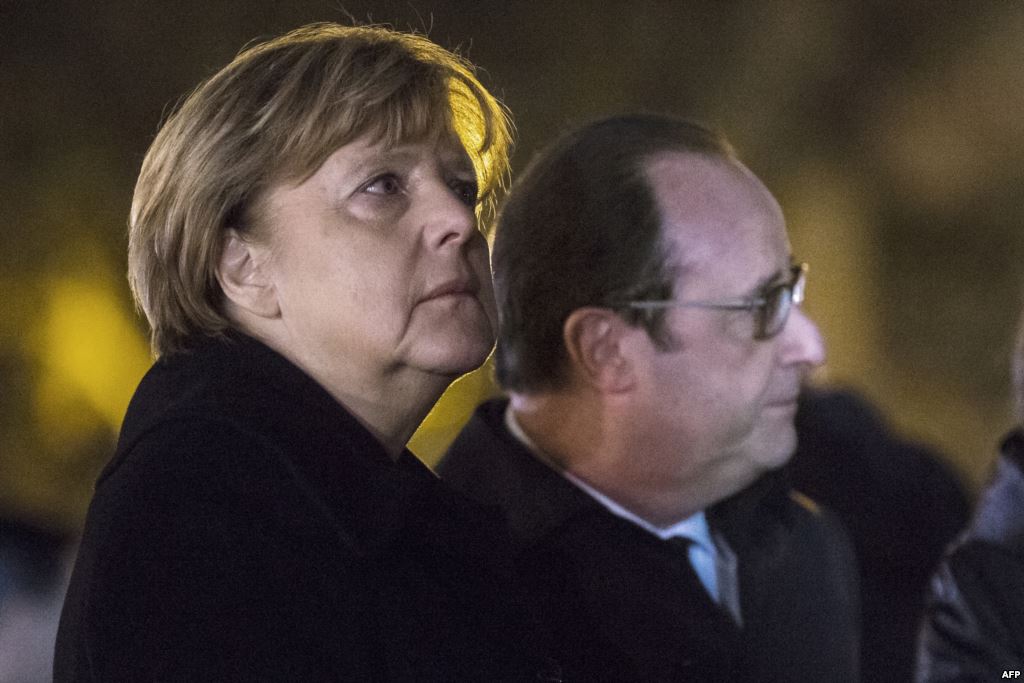 German Chancellor Angela Merkel and French President Francois Hollande pay their respects to the victims of the November 13 Paris attacks on the Place de la Republic in Paris on November 25