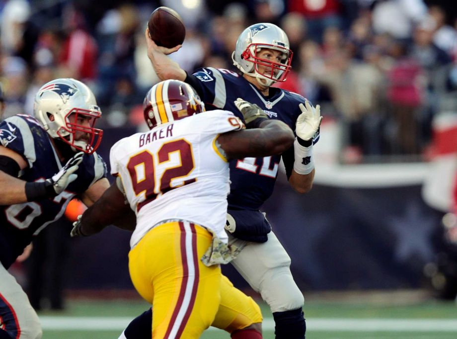 New England Patriots quarterback Tom Brady passes over Washington Redskins defensive end Chris Baker during the second half of an NFL football game Sunday Nov. 8 2015 in Foxborough Mass