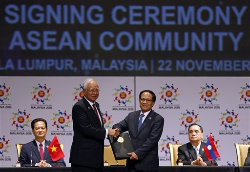 Landmark achievement Malaysian Prime Minister Najib Razak center left passes an signed document to ASEAN Secretary General Le Luong Minh center right of Vietnam after the signing ceremony of the 2015 Kuala Lumpur Declaration on the Establishment of