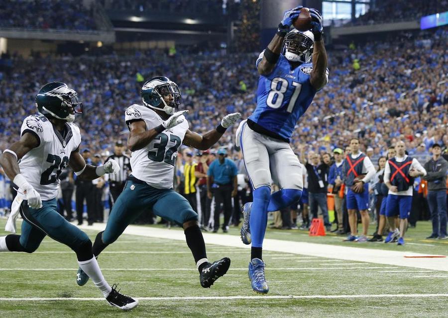 Detroit Lions wide receiver Calvin Johnson catches a 25-yard pass for a touchdown defended by Philadelphia Eagles strong safety Walter Thurmond and cornerback Eric Rowe during the first half of an NFL football game Thursday Nov. 26 2015