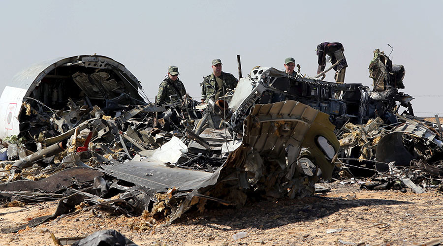 Military investigators from Russia stand near the debris of a Russian airliner at the site of its crash at the Hassana area in Arish city north Egypt