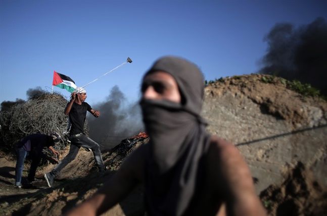 Palestinian protesters clash with Israeli soldiers on the Israeli border with Gaza in Bureij central Gaza Strip Friday Nov. 13 2015