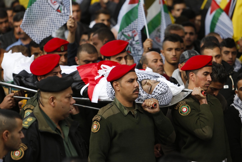 Palestinian security officers carry the body of 16-year-old Ibrahim Dawood during his funeral in the West Bank city of Ramallah. Ibrahim died of his wounds sustained during clashes with Israeli soldiers two weeks ago near the Beit El settlement