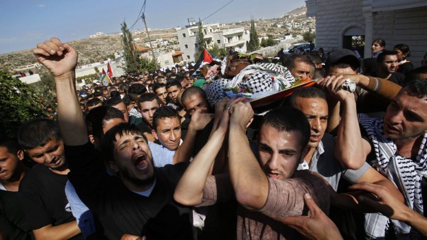 Palestinian mourners carry the body of 22 year-old Raed Jaradat during his funeral in the West Bank village of Sa'ir near Hebron on Sunday