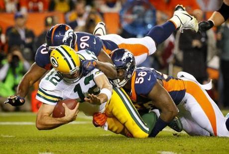 Green Bay Packers quarterback Aaron Rodgers is sacked by Denver Broncos defensive end Antonio Smith and outside linebacker Von Miller during the second half of an NFL football game Sunday Nov. 1 2015 in Denver