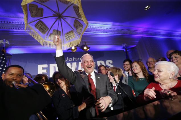 Louisiana Gov.-elect John Bel Edwards holds up an umbrella as he reacts with supporters including his mother Dora Jean Edwards, at his election night watch party in New Orleans