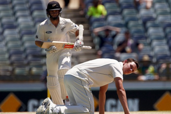 Australia's Josh Hazlewood falls over on the pitch trying to stop a boundary hit by Kane Williamson