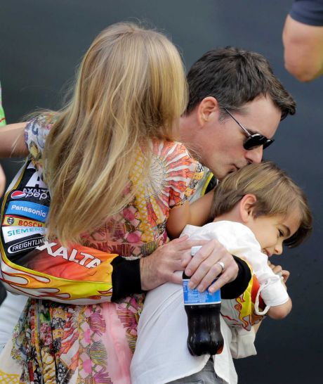 Jeff Gordon kisses his son Leo as he carries his daughter Ella while he waits backstage for the driver introductions at the NASCAR Sprint Cup Series auto race Sunday Nov. 22 2015 at Homestead Miami Speedway in Homestead Fla