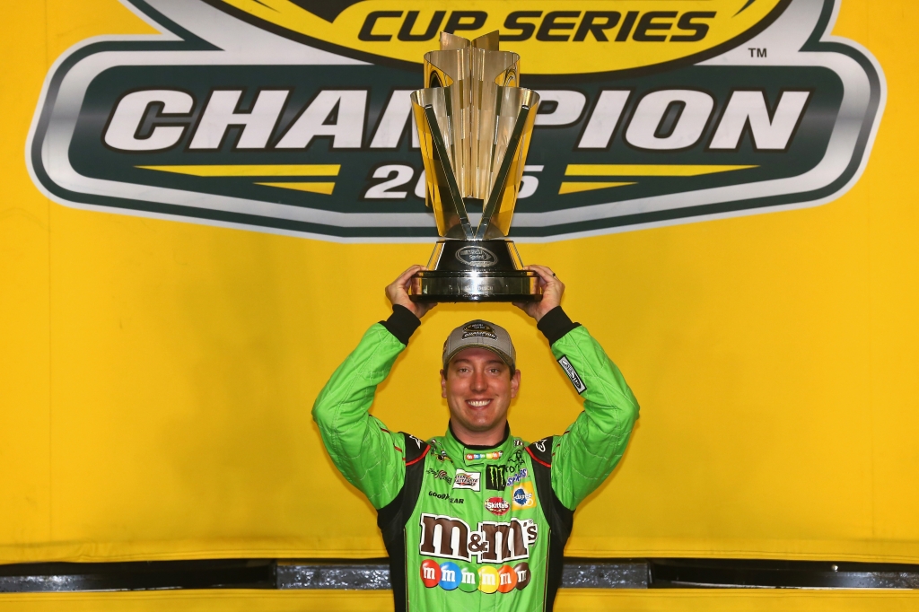 Kyle Busch driver of the #18 M&M's Crispy Toyota poses with the trophy in Victory Lane after winning the series championship and the NASCAR Sprint Cup Series Ford Eco Boost 400 at Homestead Miami Speedway