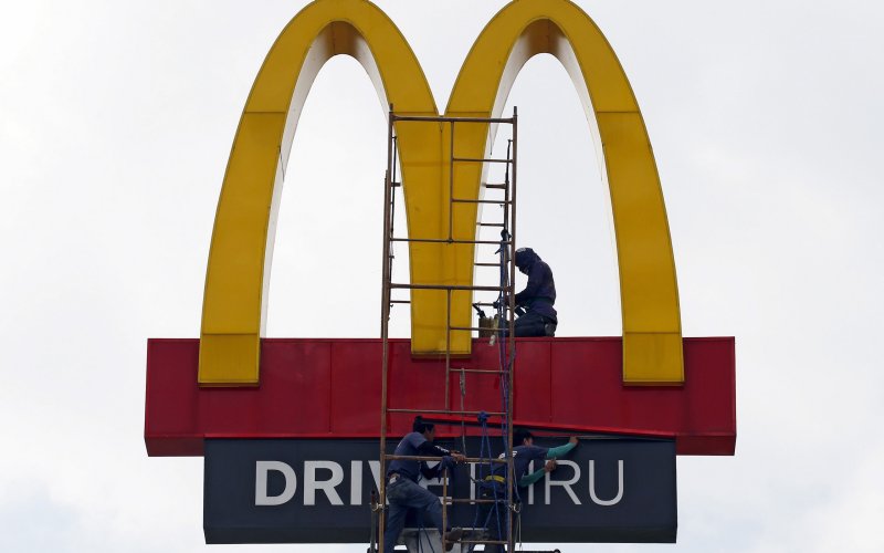 Workers repair the logo on a McDonald's sign in Paranaque Metro Manila