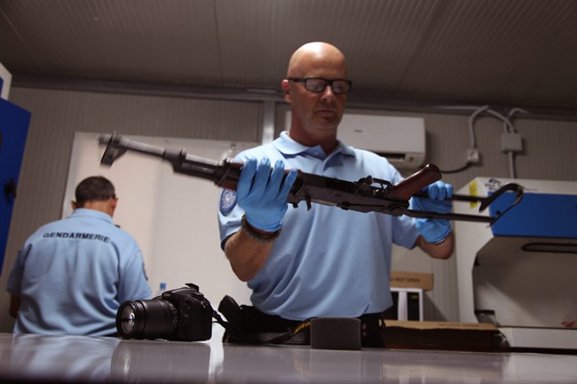 A United Nations investigator inspects a weapon that was allegedly used by gunmen during the recent attacks on the Radisson Blu hotel in Bamako Mali Tuesday Nov. 24 2015